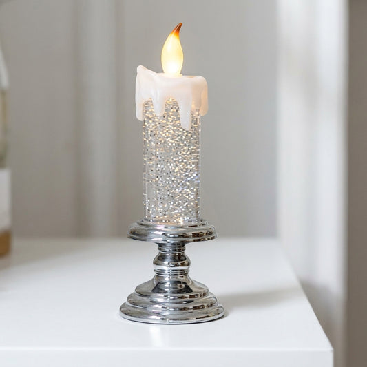 Large glitter-filled LED candle with cream wax drip top and polished chrome pedestal base