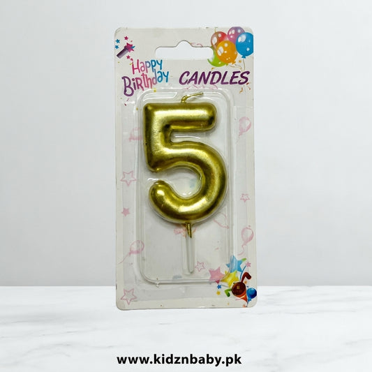 Golden number 5 birthday candle in retail packaging with colorful balloon and star designs