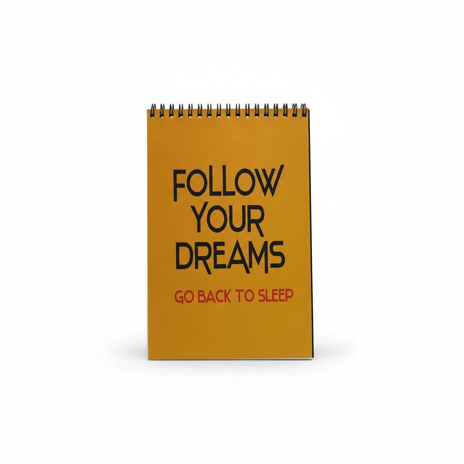 Gold spiral-bound drafting notebook with black text 'Follow Your Dreams' and red text 'Go Back To Sleep' on cover