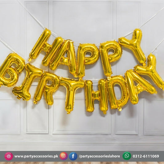 Gold foil letter balloons spelling HAPPY BIRTHDAY hanging on white wall