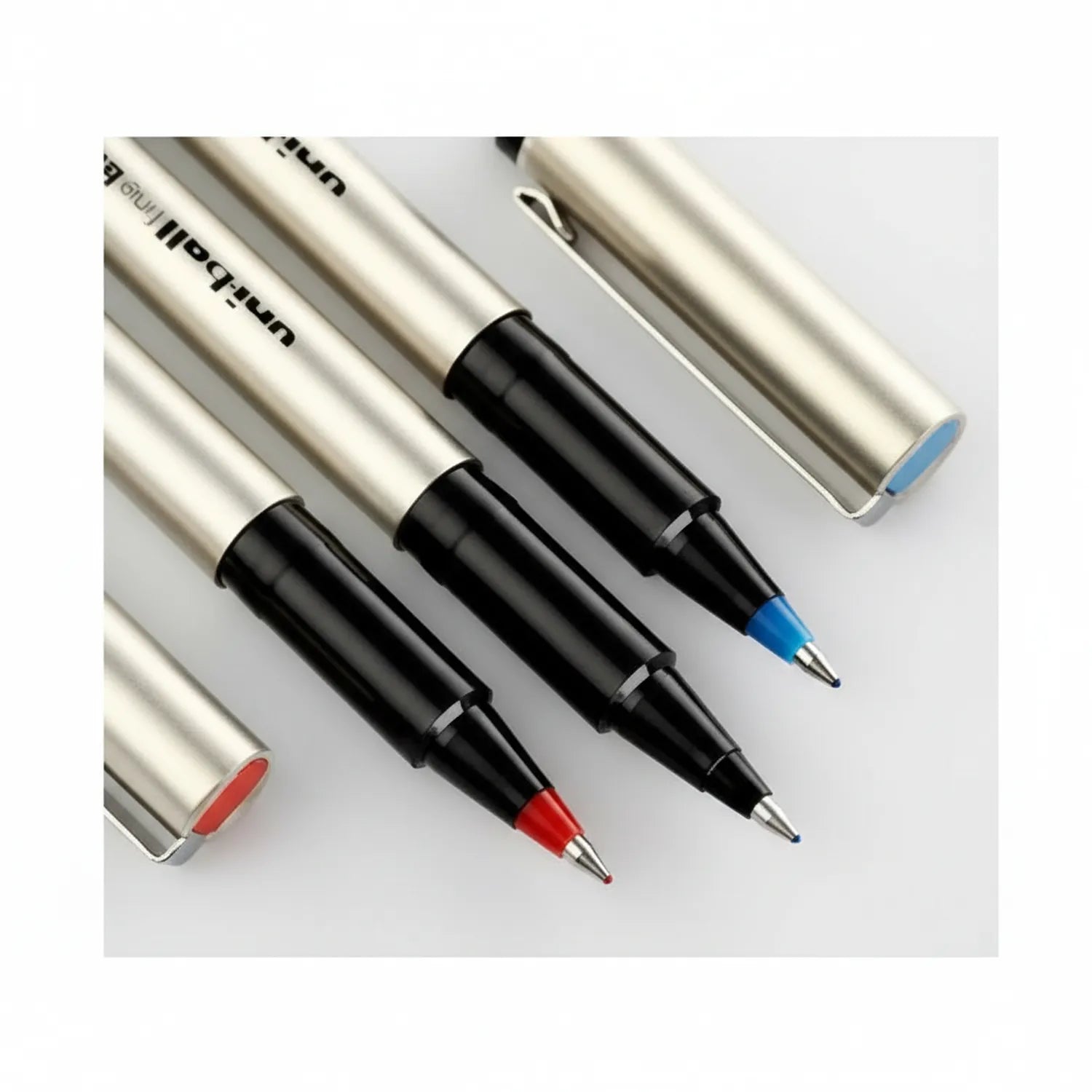 Four Uni-ball Delux UB-177 gel pens with silver barrels displayed at an angle, showing red, black, blue, and light blue ink tips.