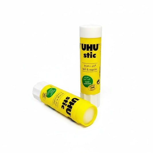 Two UHU Stic 21G glue sticks with bright yellow packaging and white caps, displayed at an angle on white background