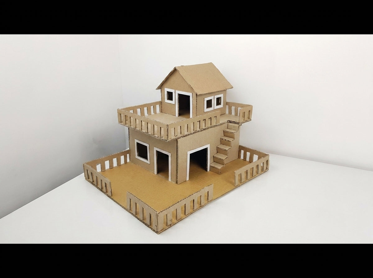 Two-story tan cardboard house model with white window frames, wooden railings, stairs, and rooftop deck