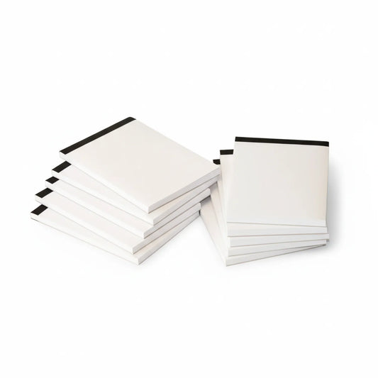 Multiple white A6 notepads with black adhesive strip binding, showing stack of 100-page notepads displayed at angle