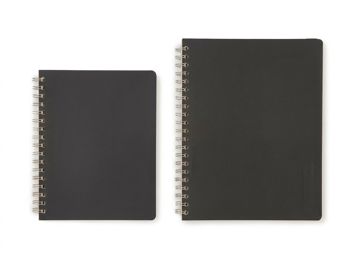 Two black spiral-bound notebooks with metal rings shown side by side against white background