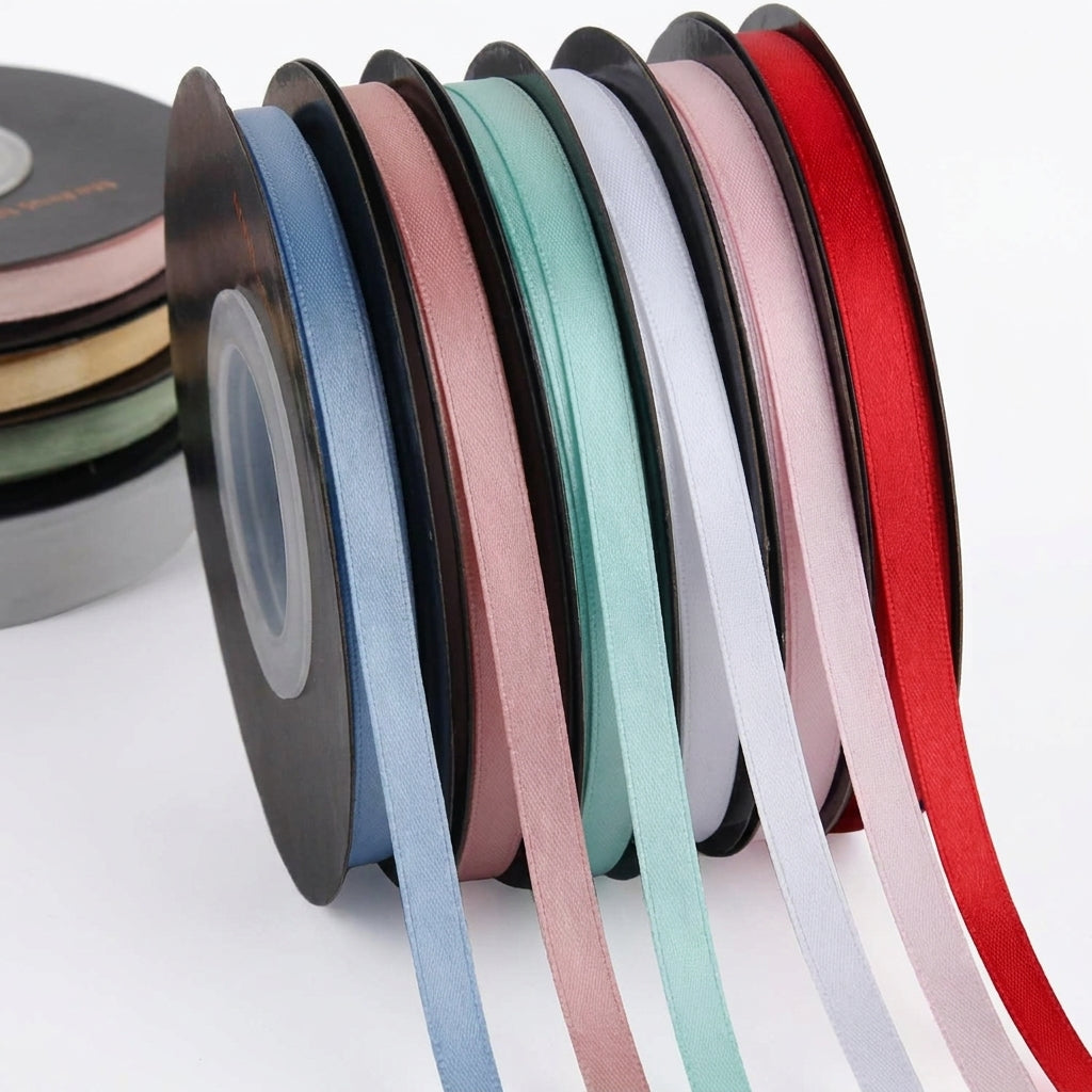 Eight spools of colorful decorative ribbons in blue, rose, pink, mint, white, lavender, and red arranged in a fan display