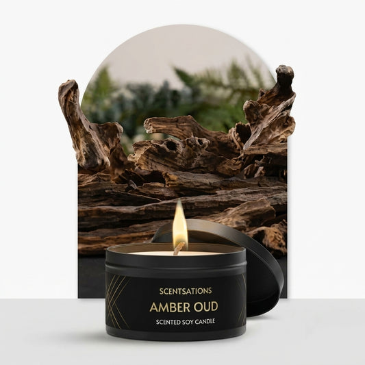 Scentsations Amber Oud scented soy candle in black tin with lit flame, displayed with driftwood backdrop