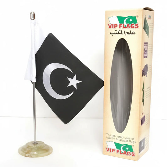 VIP Flags Table Flag M 947 showing Pakistan flag with white crescent and star on black fabric, mounted on clear plastic weighted base with white pole, displayed next to cream packaging box